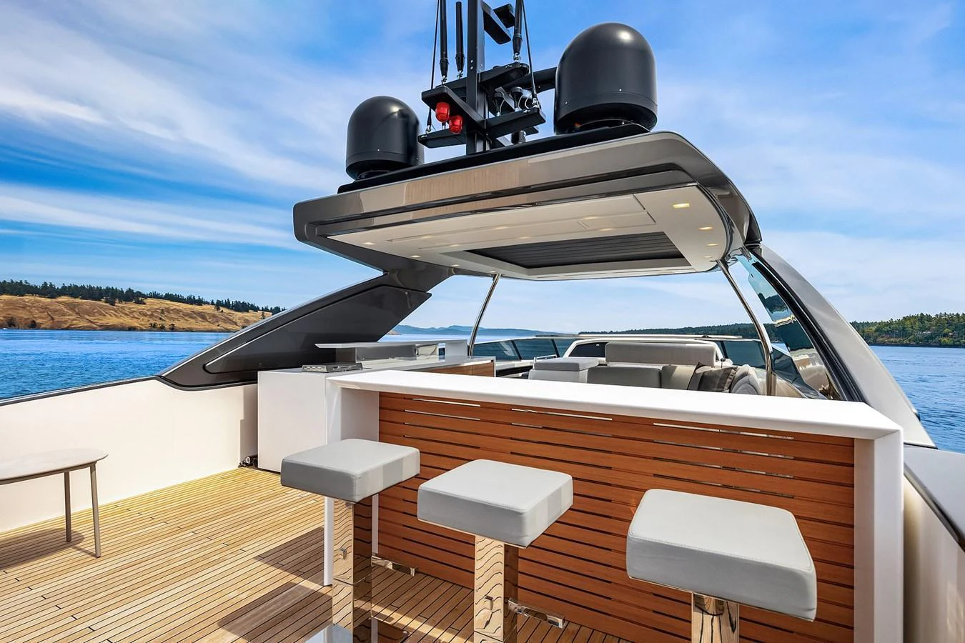 The flybridge features a sleek bar area with modern stools and a retractable roof, perfect for entertaining. aboard ESSENZA Yacht for Sale