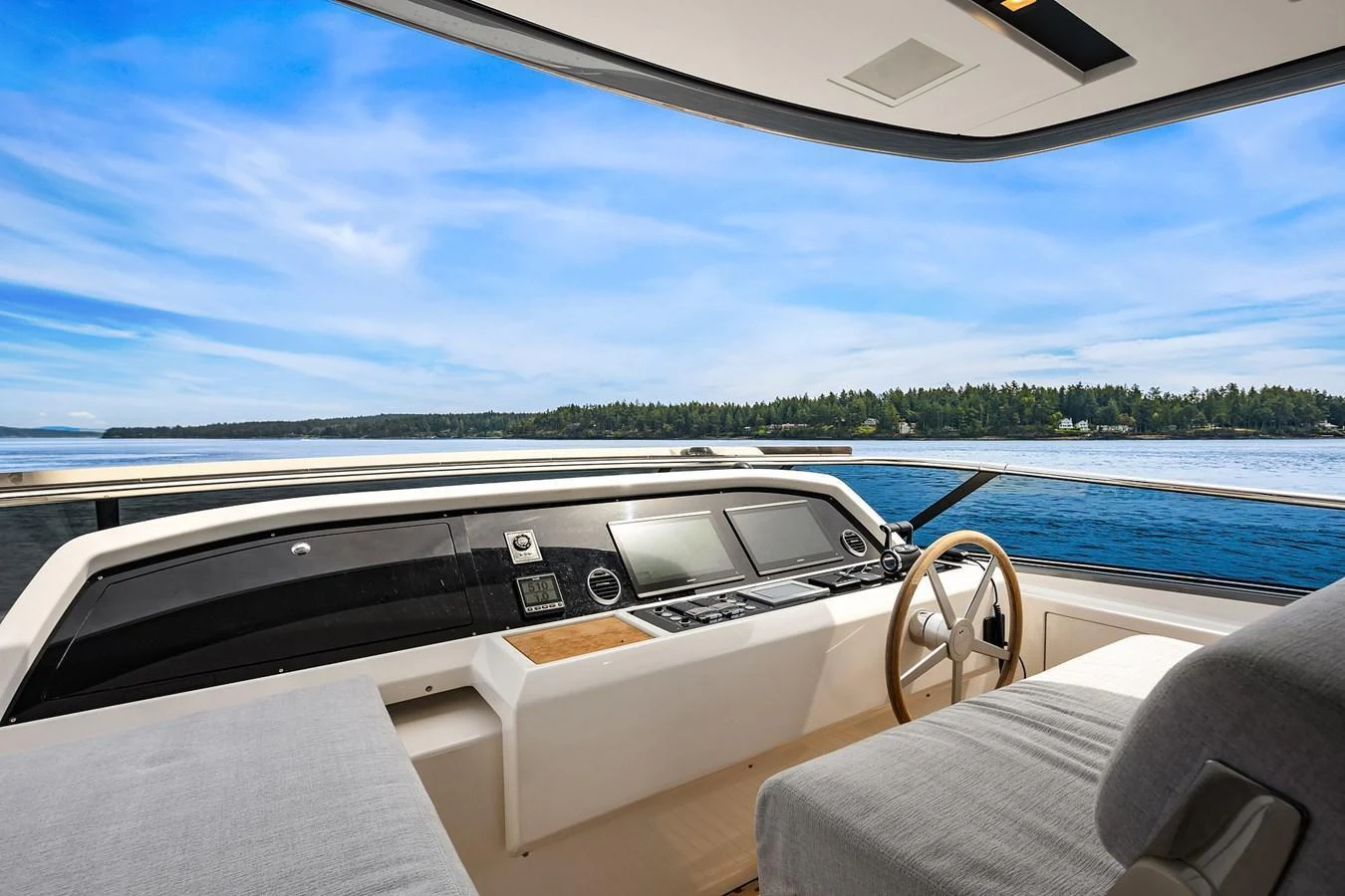 The helm station offers a panoramic view of the serene waters and lush shoreline. aboard ESSENZA Yacht for Sale