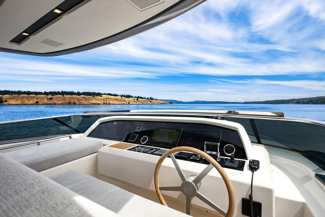 The helm station offers a panoramic view of the serene waters and distant shoreline. aboard ESSENZA Yacht for Sale
