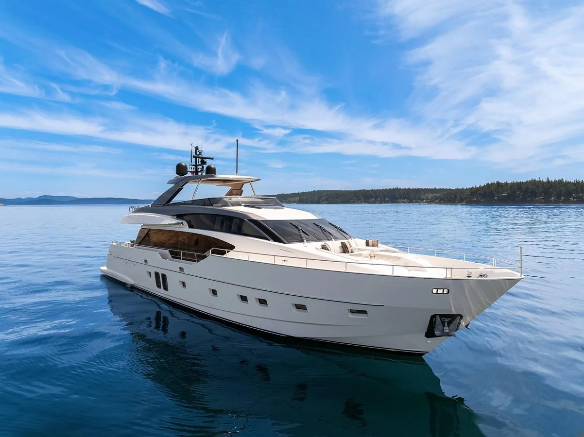 A sleek and modern yacht glides gracefully on calm waters under a clear blue sky. aboard ESSENZA Yacht for Sale