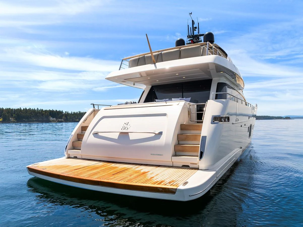 A luxurious yacht is anchored on calm waters, showcasing its elegant aft deck and sleek design. aboard ESSENZA Yacht for Sale