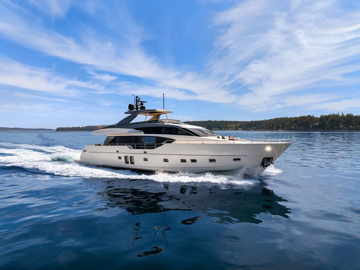 A sleek and modern yacht cruises gracefully on calm waters under a clear blue sky. aboard ESSENZA Yacht for Sale