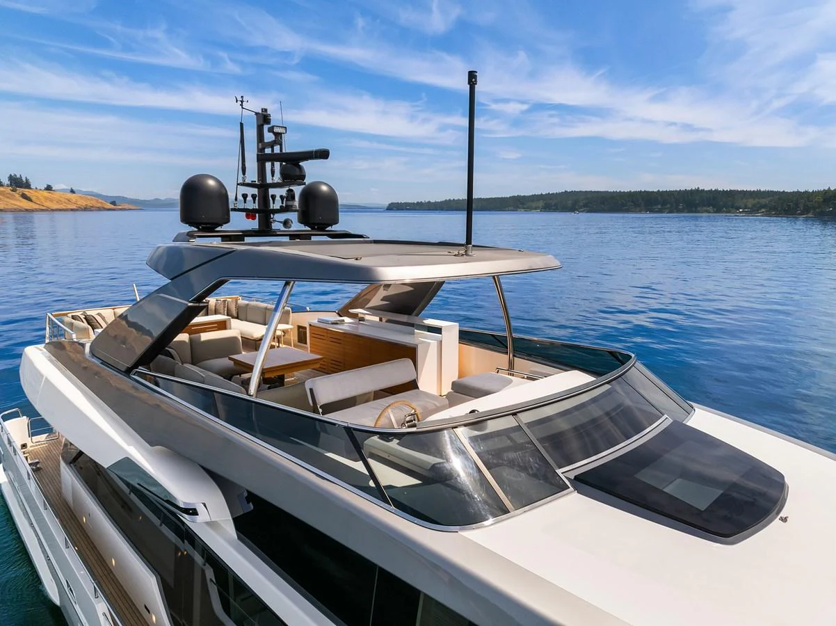 A sleek and modern flybridge yacht cruising on calm waters under a clear blue sky. aboard ESSENZA Yacht for Sale