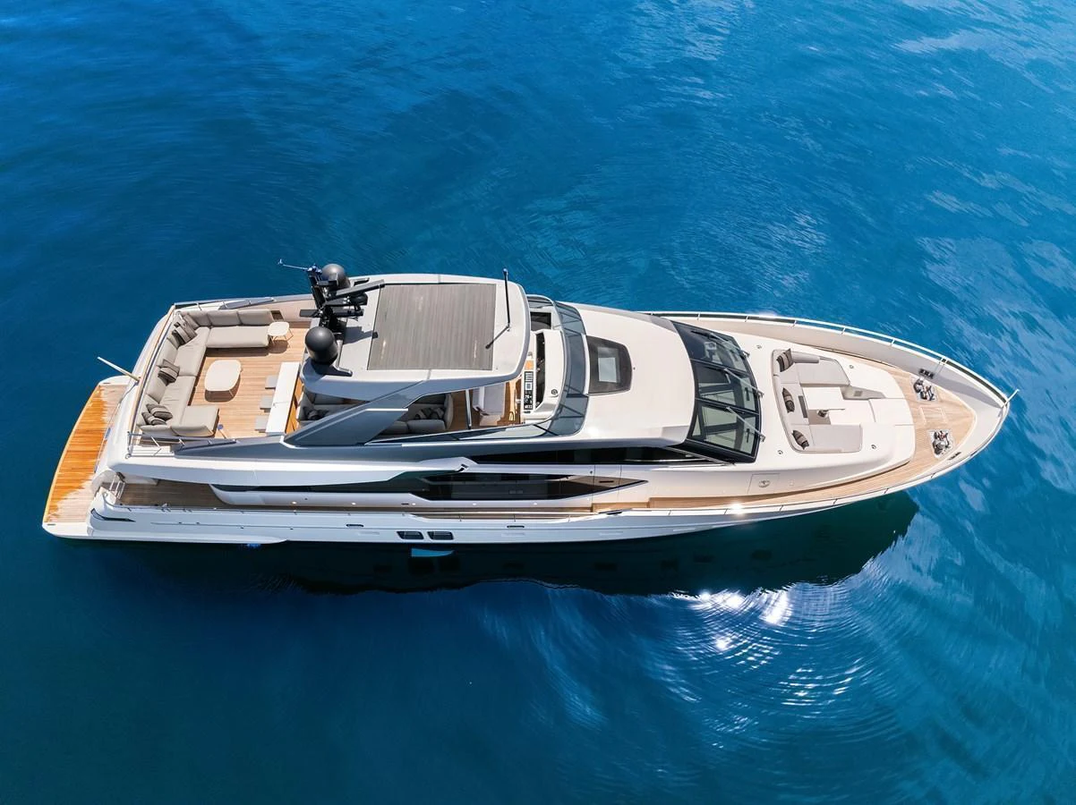 A sleek and modern yacht glides gracefully on pristine blue waters, showcasing its luxurious flybridge and spacious deck areas. aboard ESSENZA Yacht for Sale
