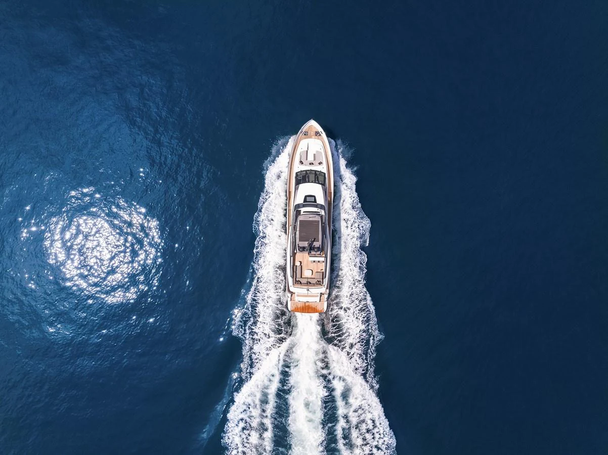 Aerial view of a luxurious yacht cruising through deep blue waters. aboard ESSENZA Yacht for Sale