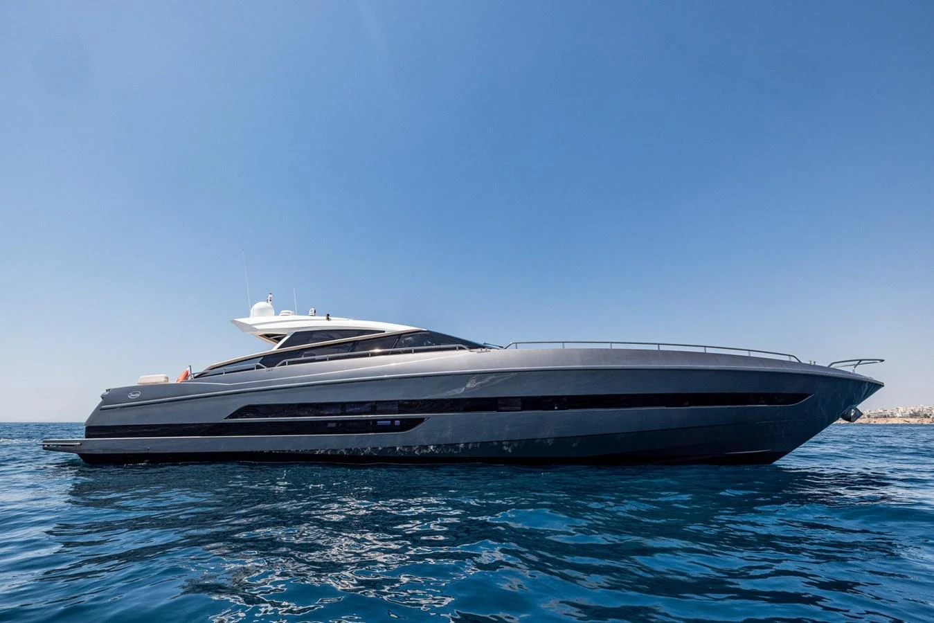 A sleek and modern yacht cruising on calm blue waters under a clear sky. aboard LIONESS Yacht for Sale