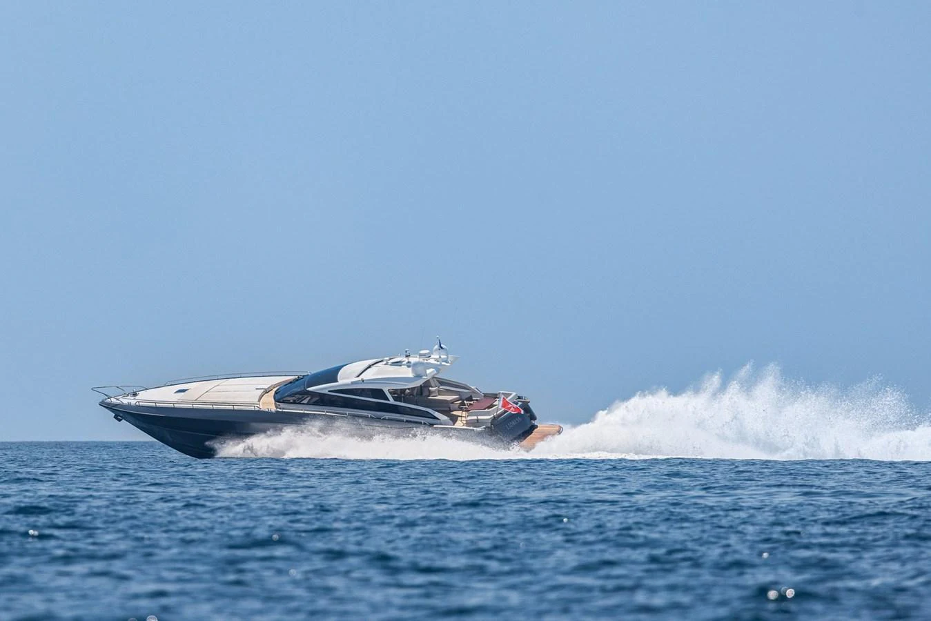 A sleek yacht cruises swiftly across the open water, leaving a trail of white foam in its wake. aboard LIONESS Yacht for Sale