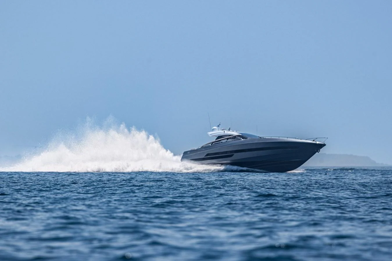A sleek yacht glides swiftly over the water, leaving a trail of white spray behind. aboard LIONESS Yacht for Sale