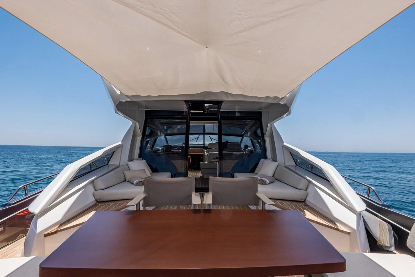 The aft deck features a spacious seating area with a wooden table under a large canopy, perfect for outdoor relaxation. aboard LIONESS Yacht for Sale