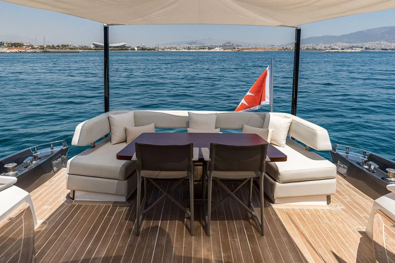 The aft deck features a comfortable seating area with a dining table, perfect for enjoying meals with a view of the sea. aboard LIONESS Yacht for Sale