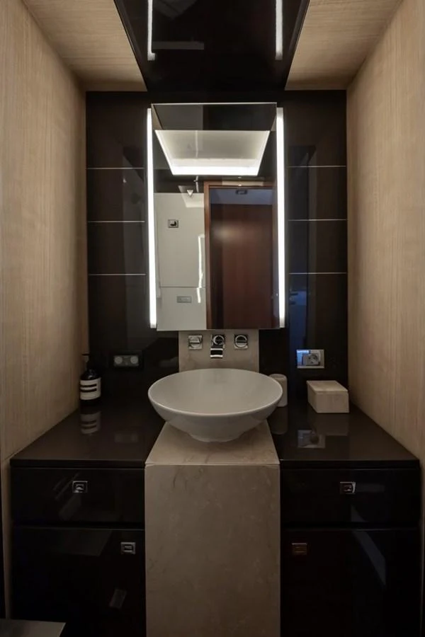 A sleek and modern yacht bathroom with elegant fixtures and ambient lighting. aboard LIONESS Yacht for Sale