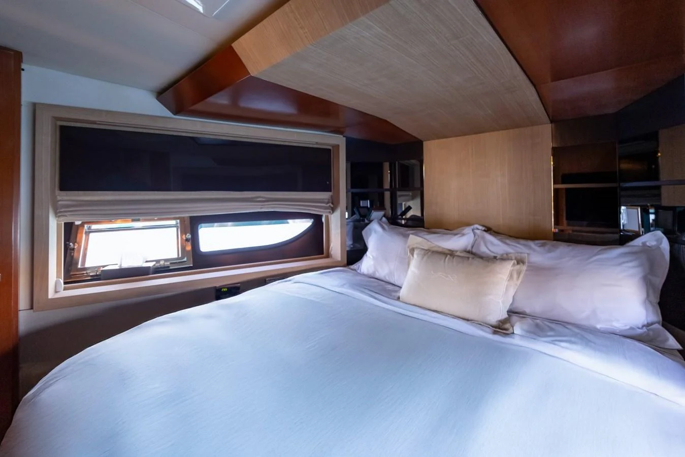 A cozy stateroom with a large bed and a window providing natural light. aboard LIONESS Yacht for Sale