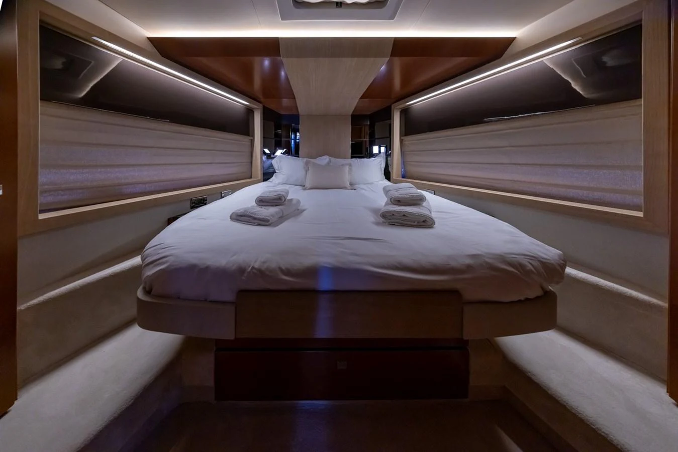 The stateroom features a luxurious bed with plush linens and ambient lighting. aboard LIONESS Yacht for Sale