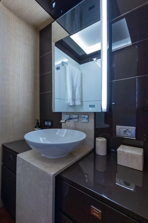 A sleek and modern yacht bathroom featuring a stylish vessel sink and contemporary fixtures. aboard LIONESS Yacht for Sale