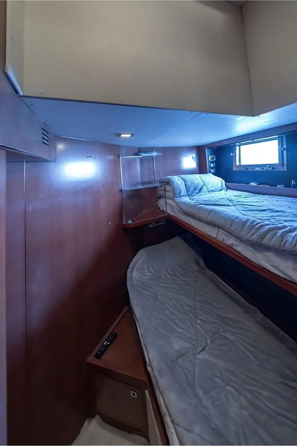 The image shows a cozy bunk cabin with wooden paneling and comfortable bedding. aboard LIONESS Yacht for Sale