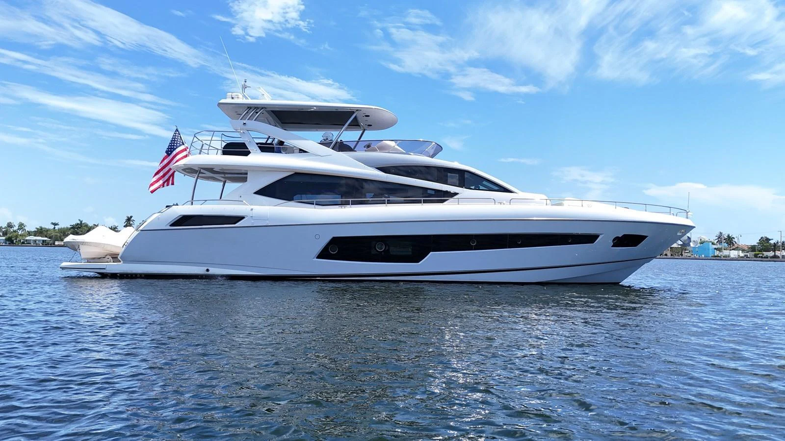 A sleek and modern yacht glides gracefully on calm waters under a clear blue sky. aboard DIRTY DAWG Yacht for Sale