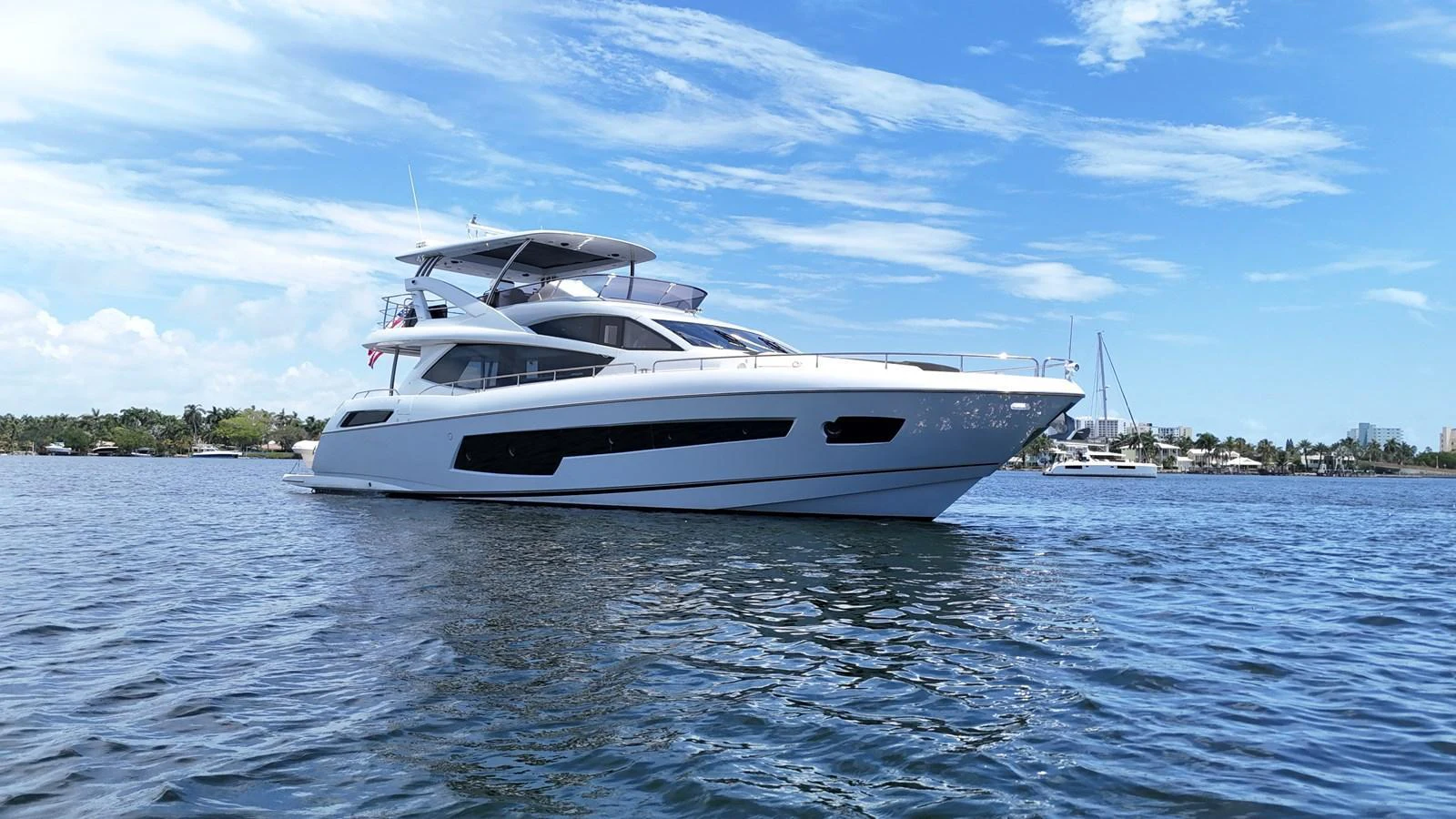 A sleek and modern yacht glides gracefully on calm waters under a clear blue sky. aboard DIRTY DAWG Yacht for Sale