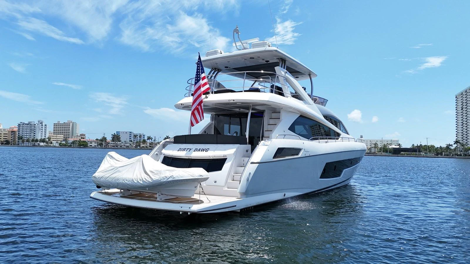 A sleek and modern yacht cruising on calm waters with a clear blue sky backdrop. aboard DIRTY DAWG Yacht for Sale