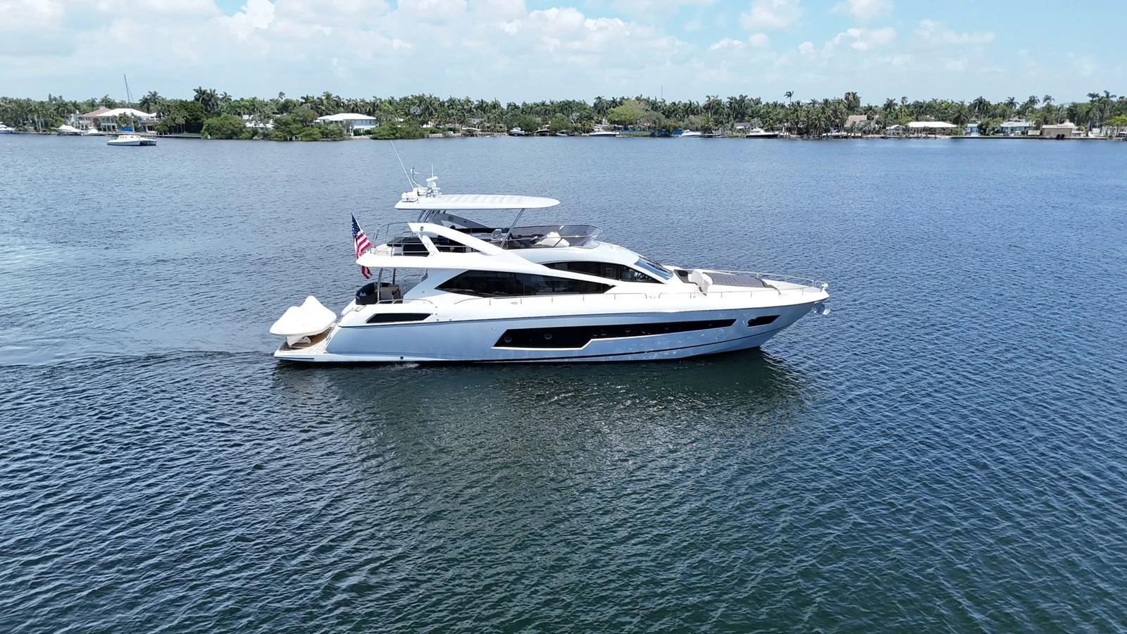 A sleek and modern yacht cruises gracefully on calm waters under a clear sky. aboard DIRTY DAWG Yacht for Sale