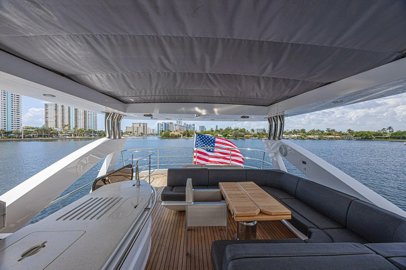 The aft deck features a comfortable seating area with a view of the water and cityscape. aboard DIRTY DAWG Yacht for Sale