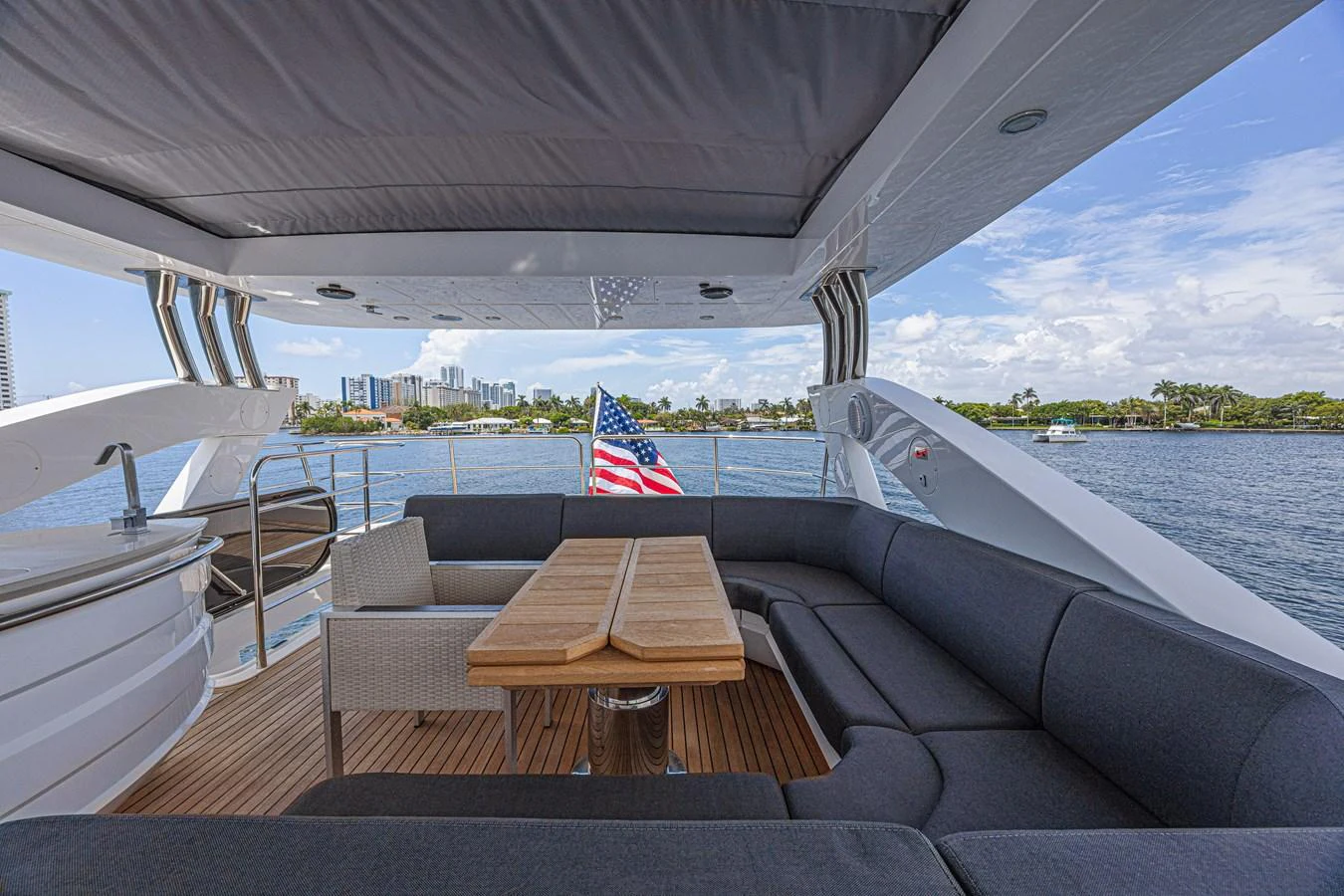 The aft deck offers a comfortable seating area with a wooden table, perfect for enjoying the views. aboard DIRTY DAWG Yacht for Sale