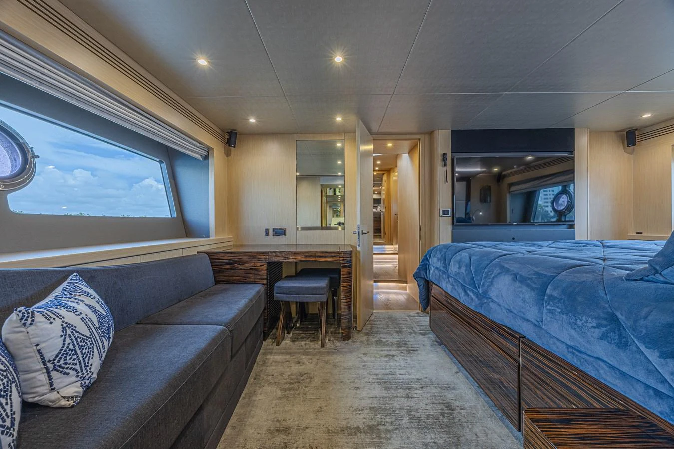 The stateroom features a plush bed, comfortable seating, and ample natural light from large windows. aboard DIRTY DAWG Yacht for Sale