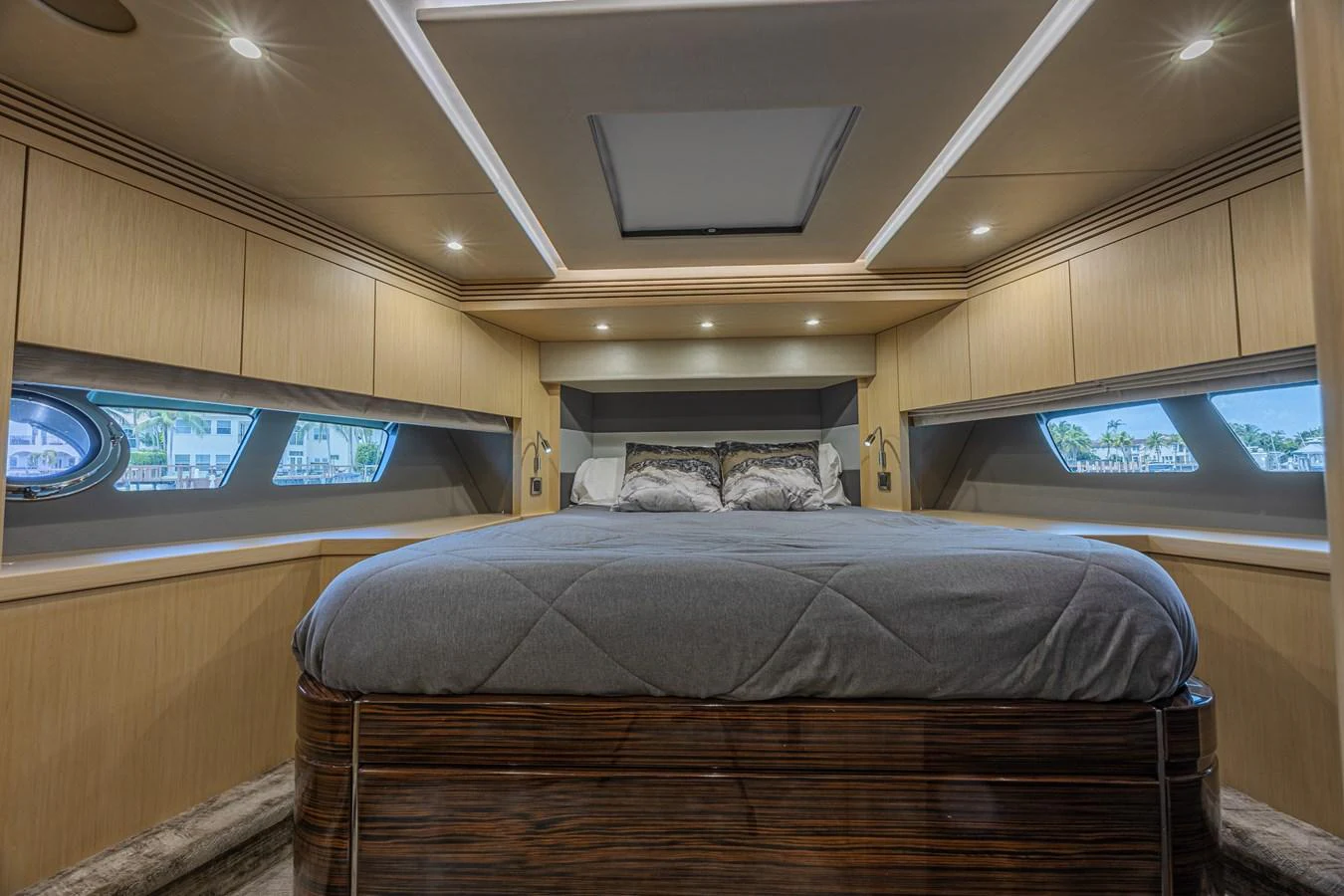 The master stateroom features a luxurious bed with ample natural light from the side windows. aboard DIRTY DAWG Yacht for Sale