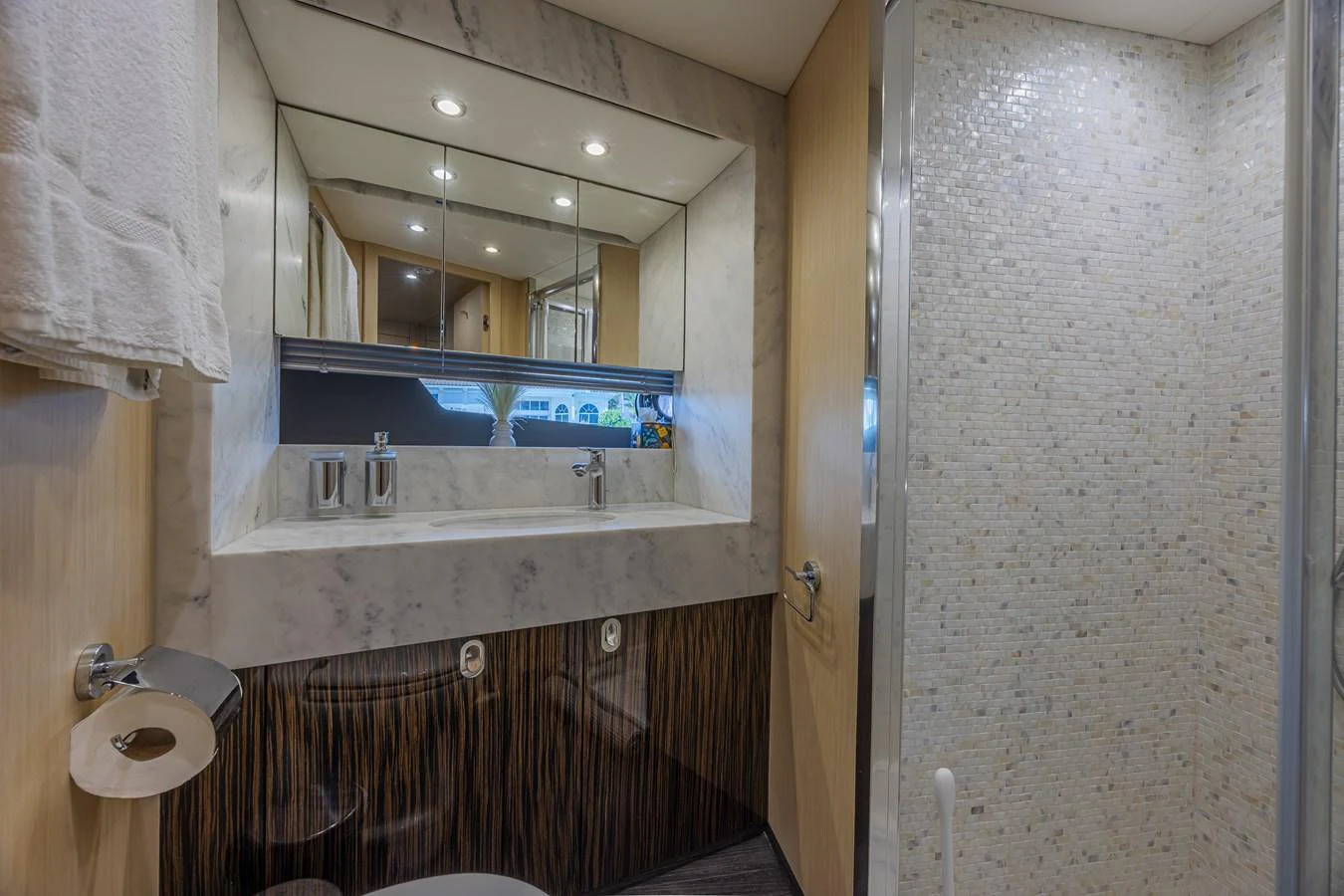 The yacht's bathroom features a modern design with a marble sink and a spacious shower area. aboard DIRTY DAWG Yacht for Sale