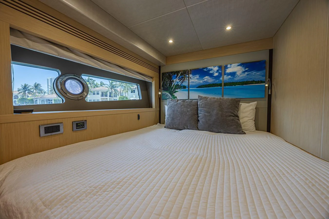 The stateroom features a cozy bed with a scenic view through the window. aboard DIRTY DAWG Yacht for Sale