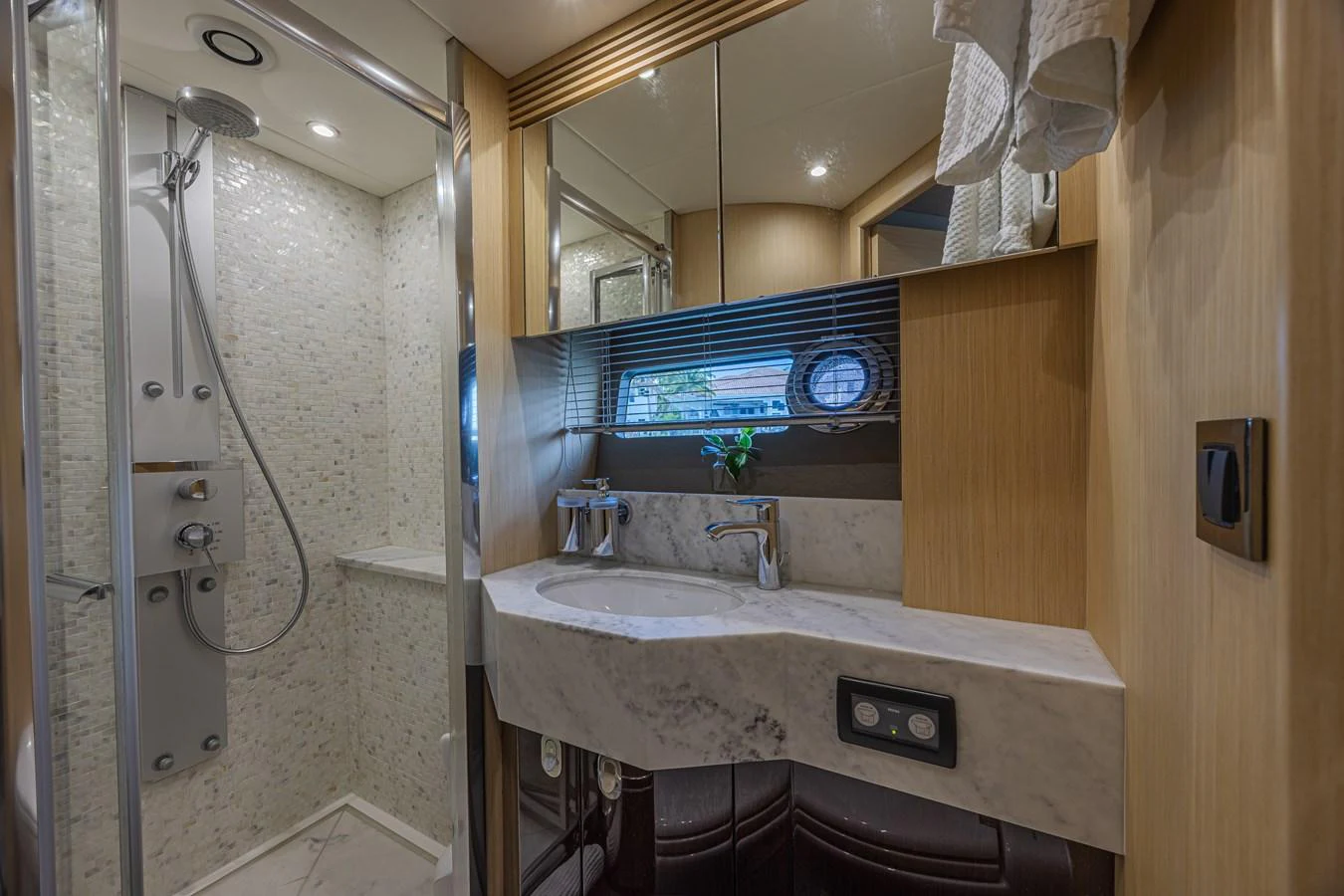 The yacht's bathroom features a modern shower and elegant sink area with ample lighting. aboard DIRTY DAWG Yacht for Sale