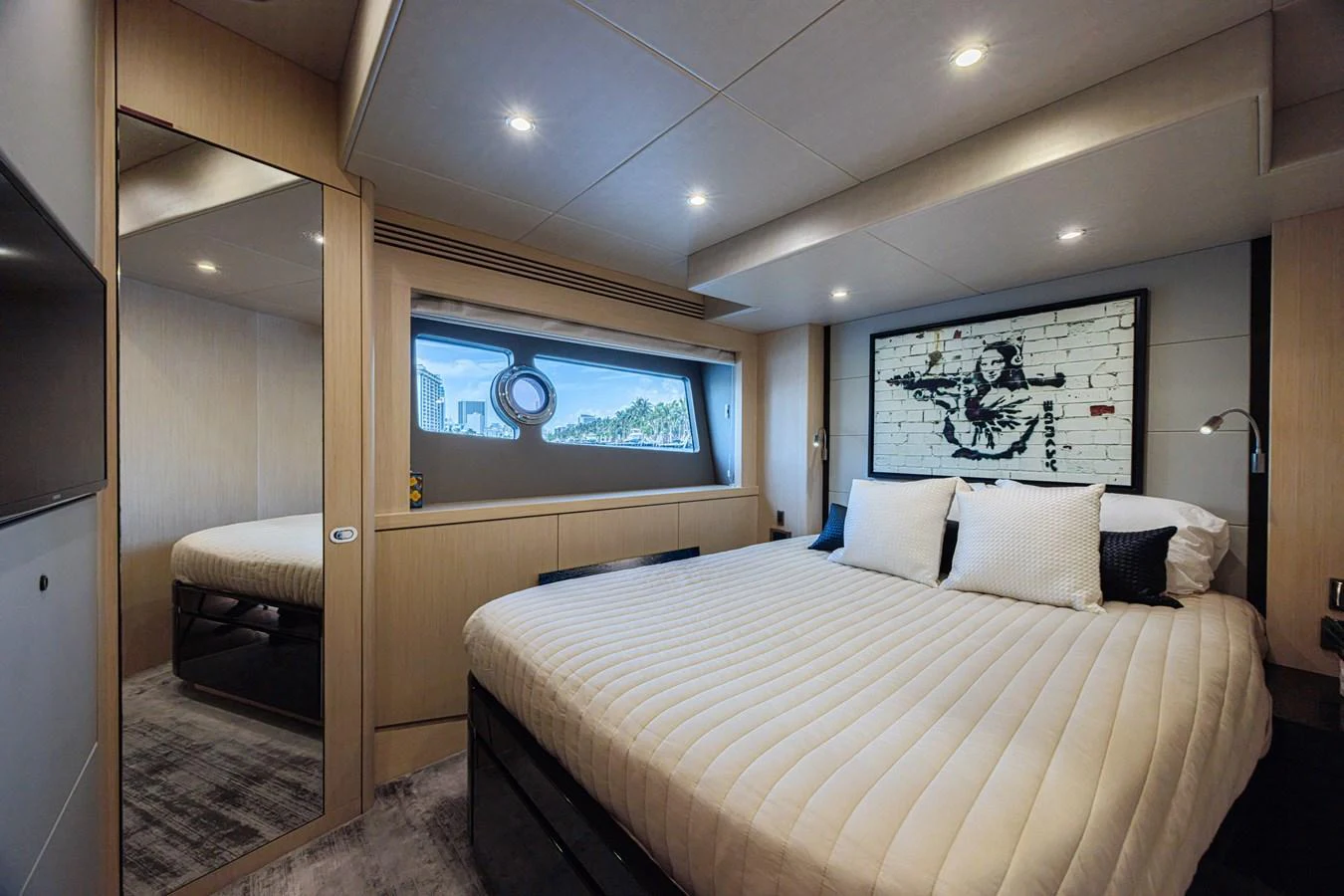 The stateroom features a luxurious bed with modern decor and ample natural light. aboard DIRTY DAWG Yacht for Sale
