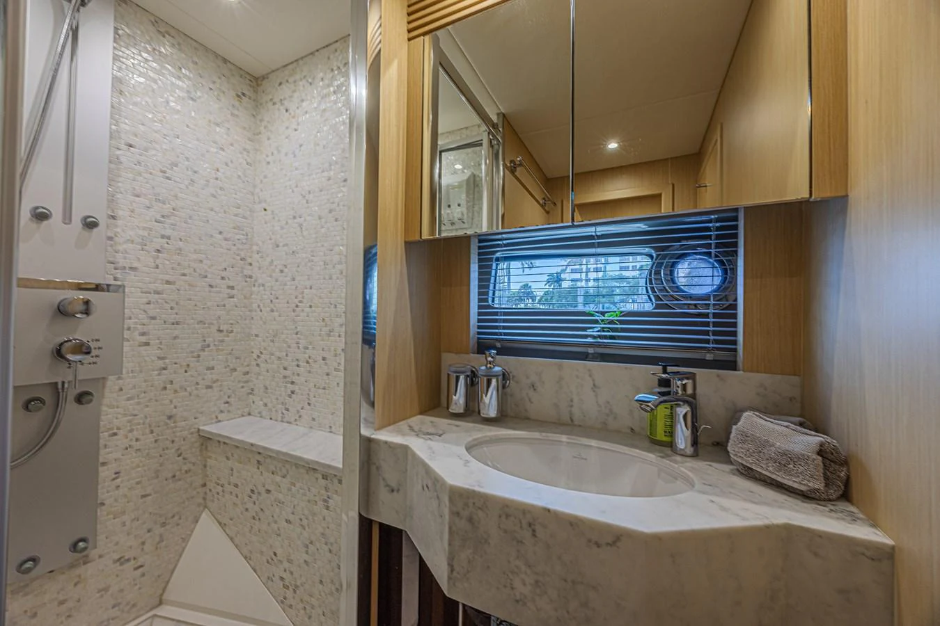 The yacht's bathroom features a modern design with a marble countertop and a spacious shower area. aboard DIRTY DAWG Yacht for Sale