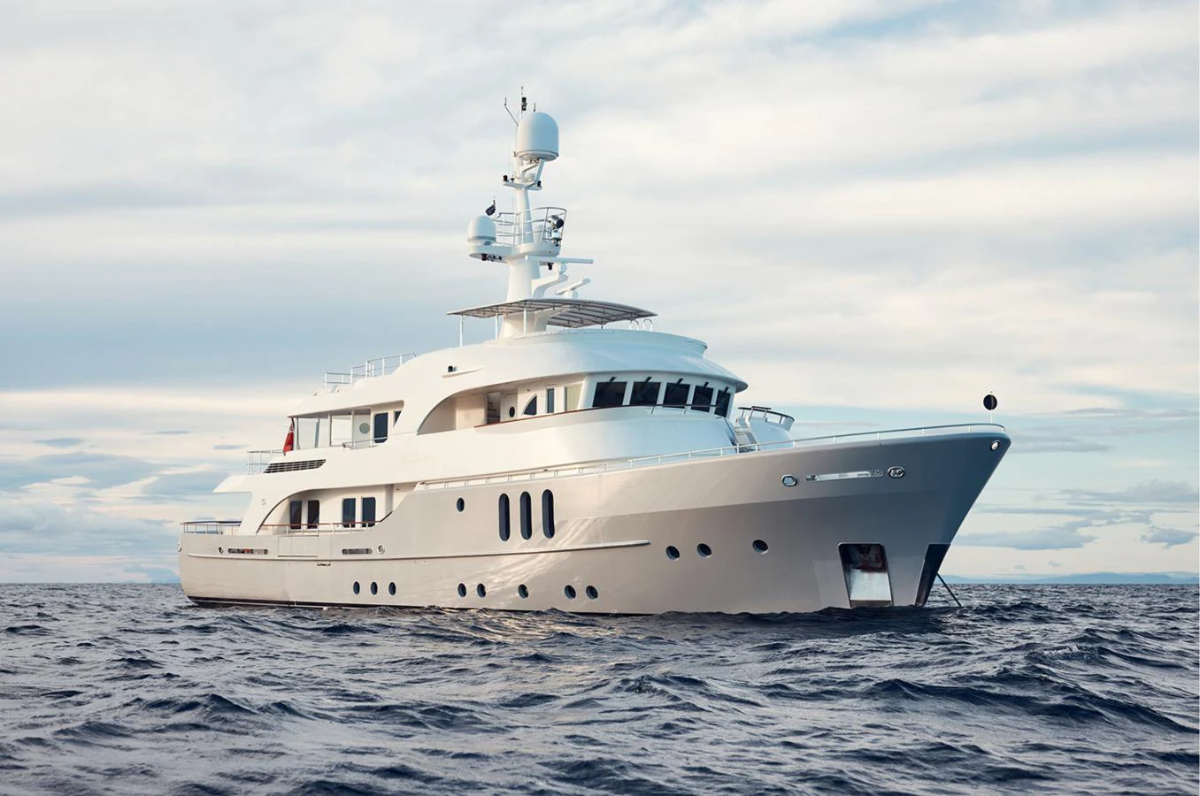 A luxurious yacht glides gracefully on the open sea under a serene sky. aboard BELUGA Yacht for Sale