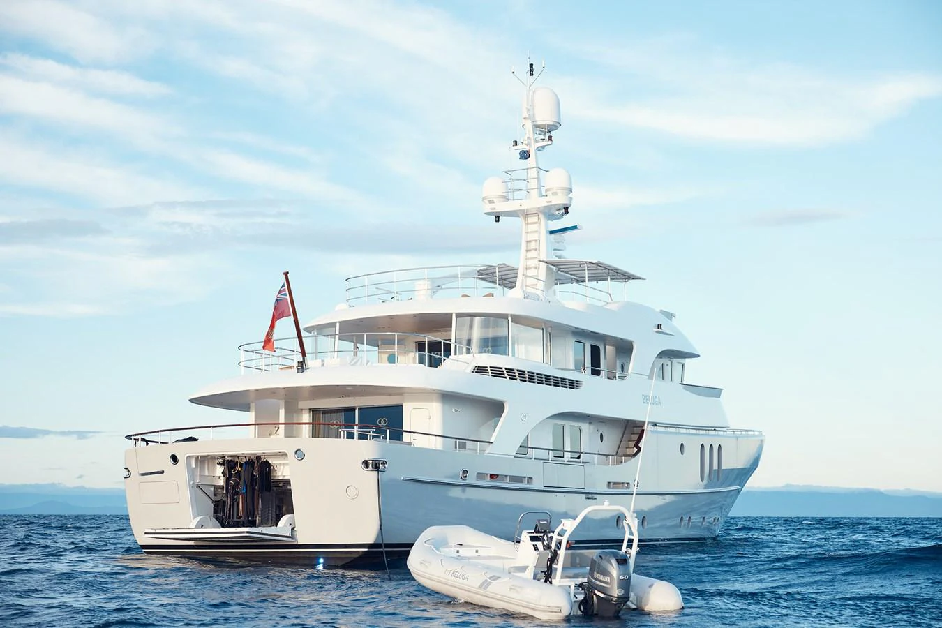 A luxurious yacht anchored on calm waters with a tender floating nearby. aboard BELUGA Yacht for Sale