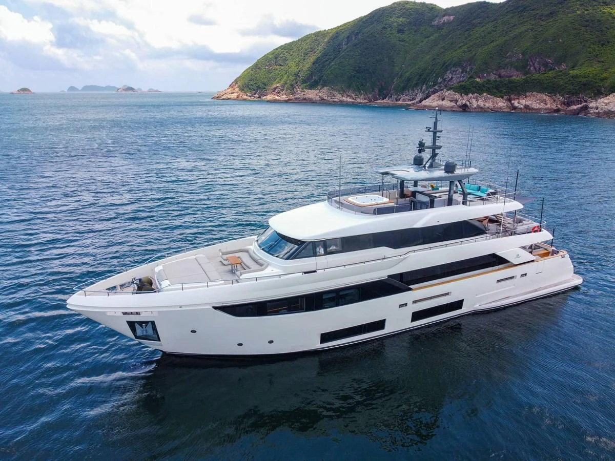 A sleek and modern yacht cruises gracefully on calm waters with scenic hills in the background. aboard CUSTOM LINE NAVETTA 33 Yacht for Sale