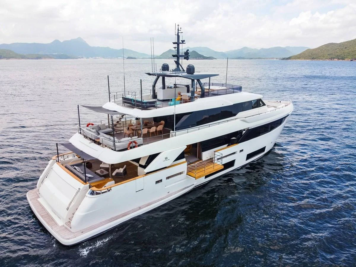 A sleek and modern yacht cruising on calm waters with scenic mountains in the background. aboard CUSTOM LINE NAVETTA 33 Yacht for Sale