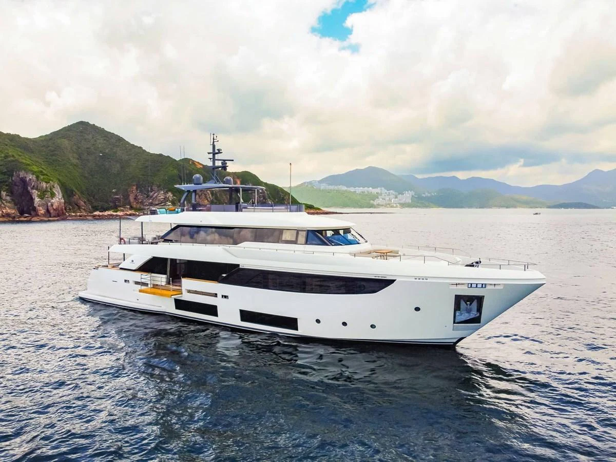 A sleek and modern yacht glides gracefully on calm waters with scenic hills in the background. aboard CUSTOM LINE NAVETTA 33 Yacht for Sale