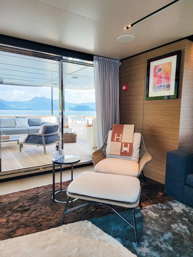 A cozy and stylish interior seating area with a view of the outdoor deck and ocean beyond. aboard CUSTOM LINE NAVETTA 33 Yacht for Sale