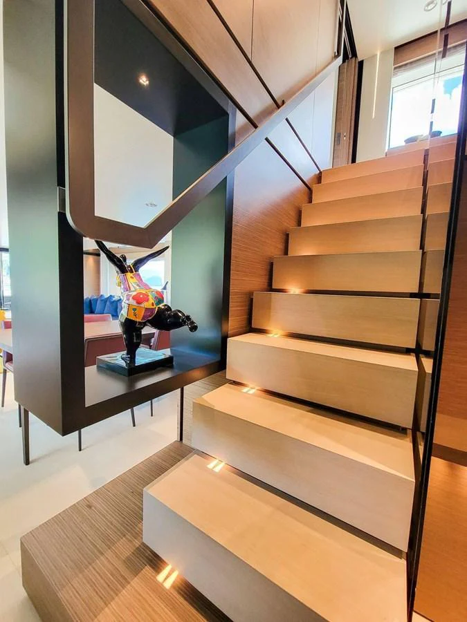 A modern staircase with sleek lighting and a decorative sculpture enhances the yacht's interior elegance. aboard CUSTOM LINE NAVETTA 33 Yacht for Sale