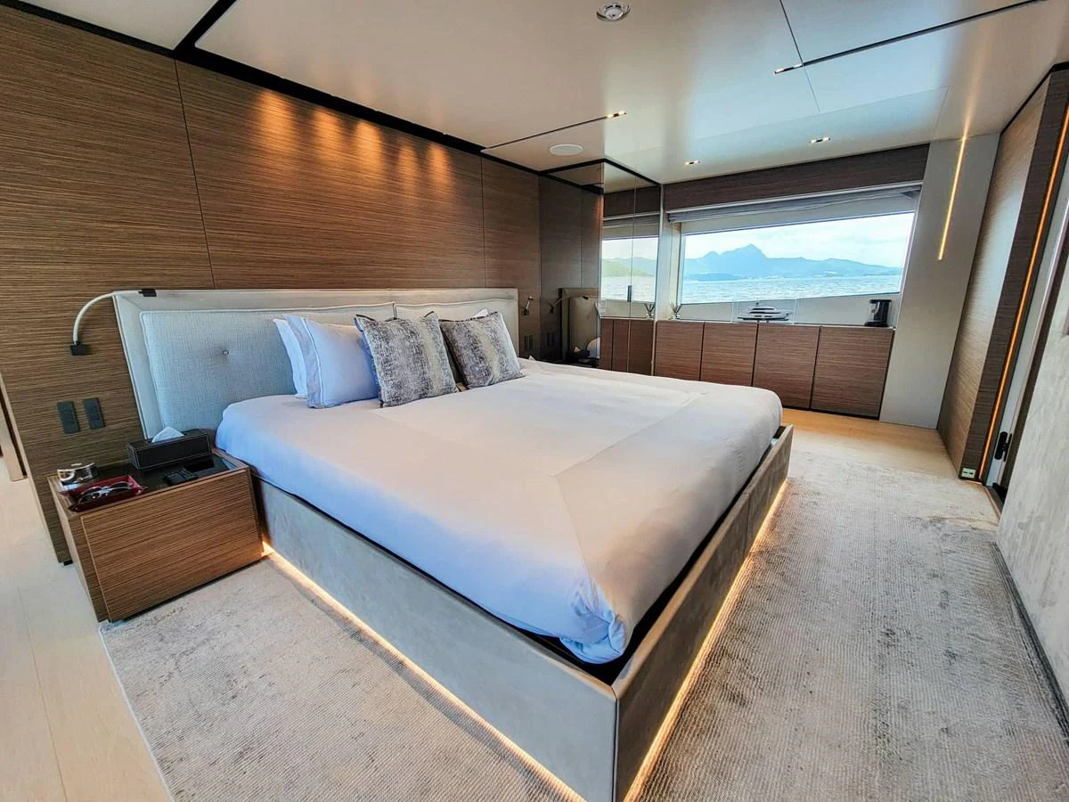 The master stateroom features a spacious bed with elegant decor and a scenic view through large windows. aboard CUSTOM LINE NAVETTA 33 Yacht for Sale