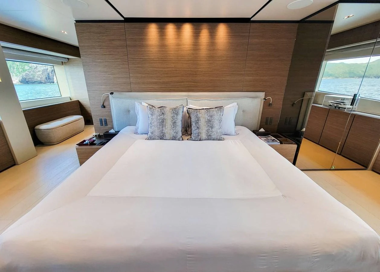 The master stateroom features a luxurious bed with plush pillows and a serene view through large windows. aboard CUSTOM LINE NAVETTA 33 Yacht for Sale