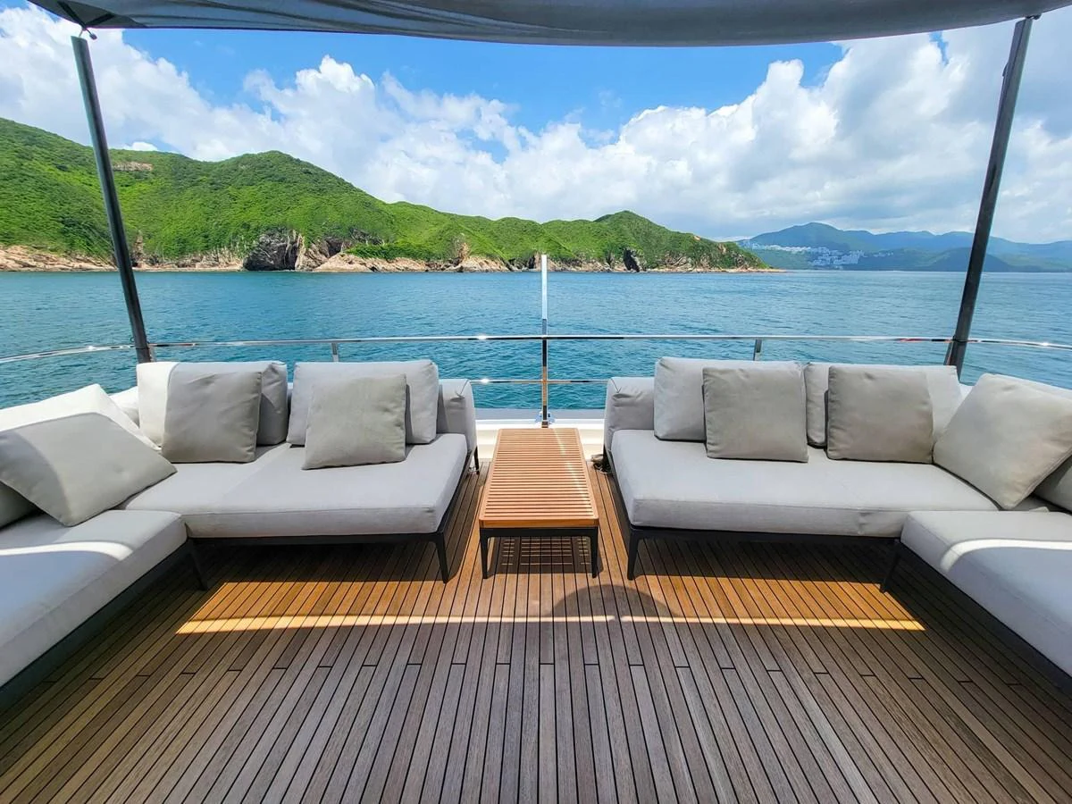 The aft deck features plush seating with a stunning view of the surrounding waters and lush green hills. aboard CUSTOM LINE NAVETTA 33 Yacht for Sale