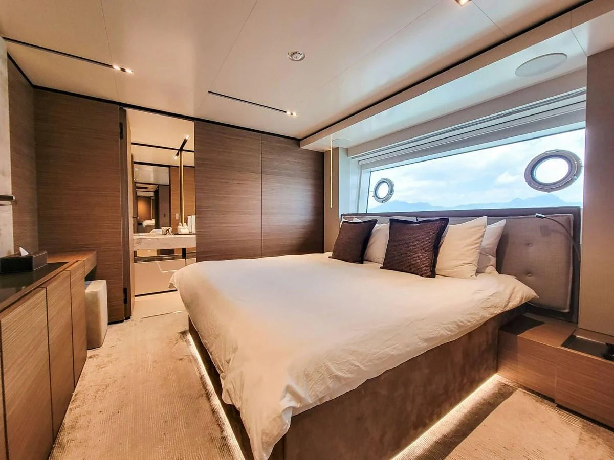 The master stateroom features a luxurious bed with a large window offering stunning ocean views. aboard CUSTOM LINE NAVETTA 33 Yacht for Sale