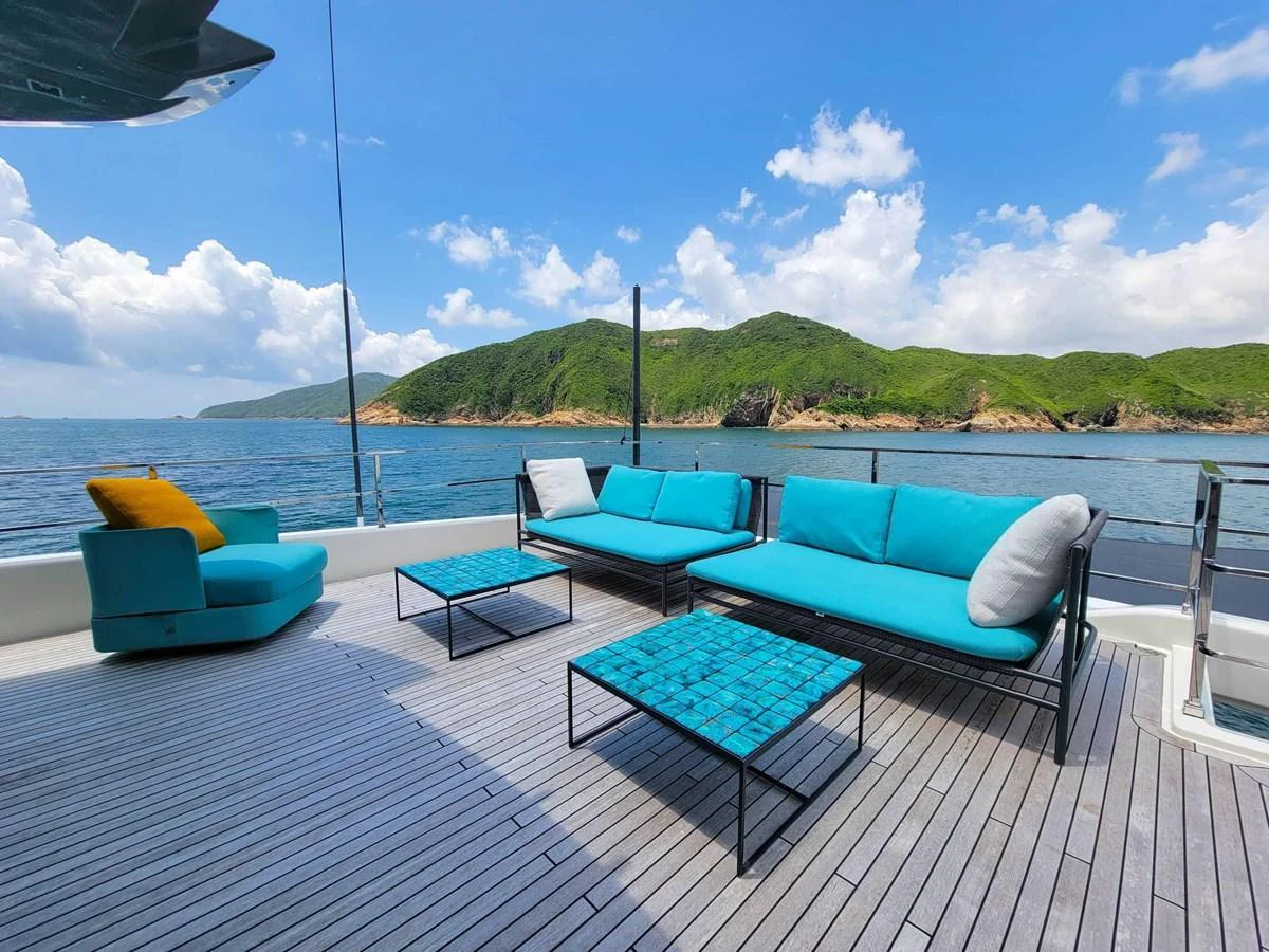 The aft deck features stylish turquoise seating with a stunning ocean and island backdrop. aboard CUSTOM LINE NAVETTA 33 Yacht for Sale