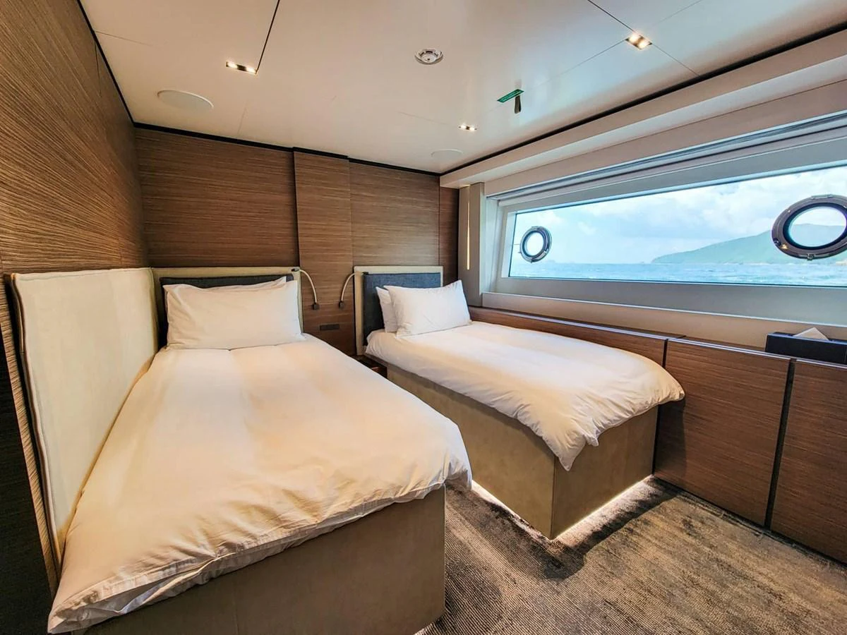 The twin stateroom offers a cozy and inviting space with large windows providing scenic ocean views. aboard CUSTOM LINE NAVETTA 33 Yacht for Sale