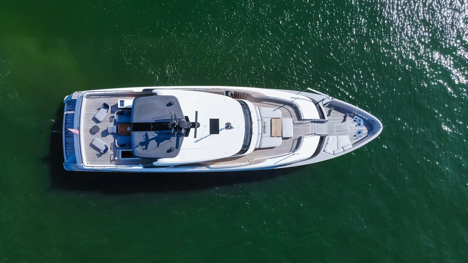 Aerial view of a sleek yacht cruising on calm green waters. aboard SANLORENZO SD96 Yacht for Sale
