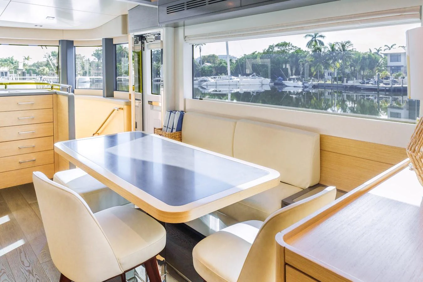 The yacht's dining area features a sleek table with comfortable seating and large windows offering scenic views. aboard FANTASEA Yacht for Sale