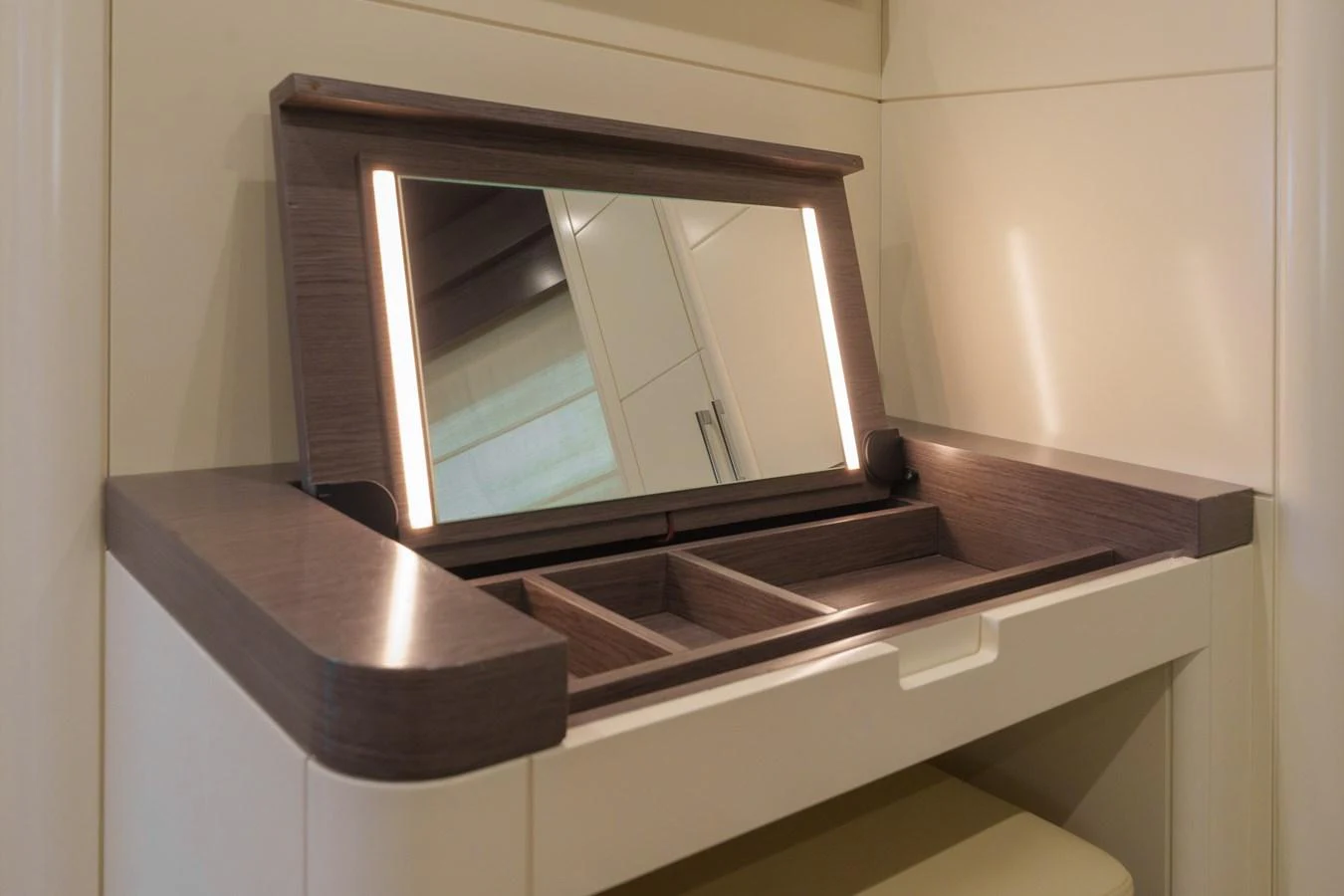 A close-up of a vanity mirror with integrated lighting and storage compartments. aboard FANTASEA Yacht for Sale