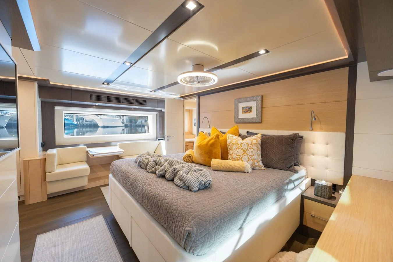The master stateroom features a luxurious bed, modern lighting, and ample natural light through large windows. aboard FANTASEA Yacht for Sale