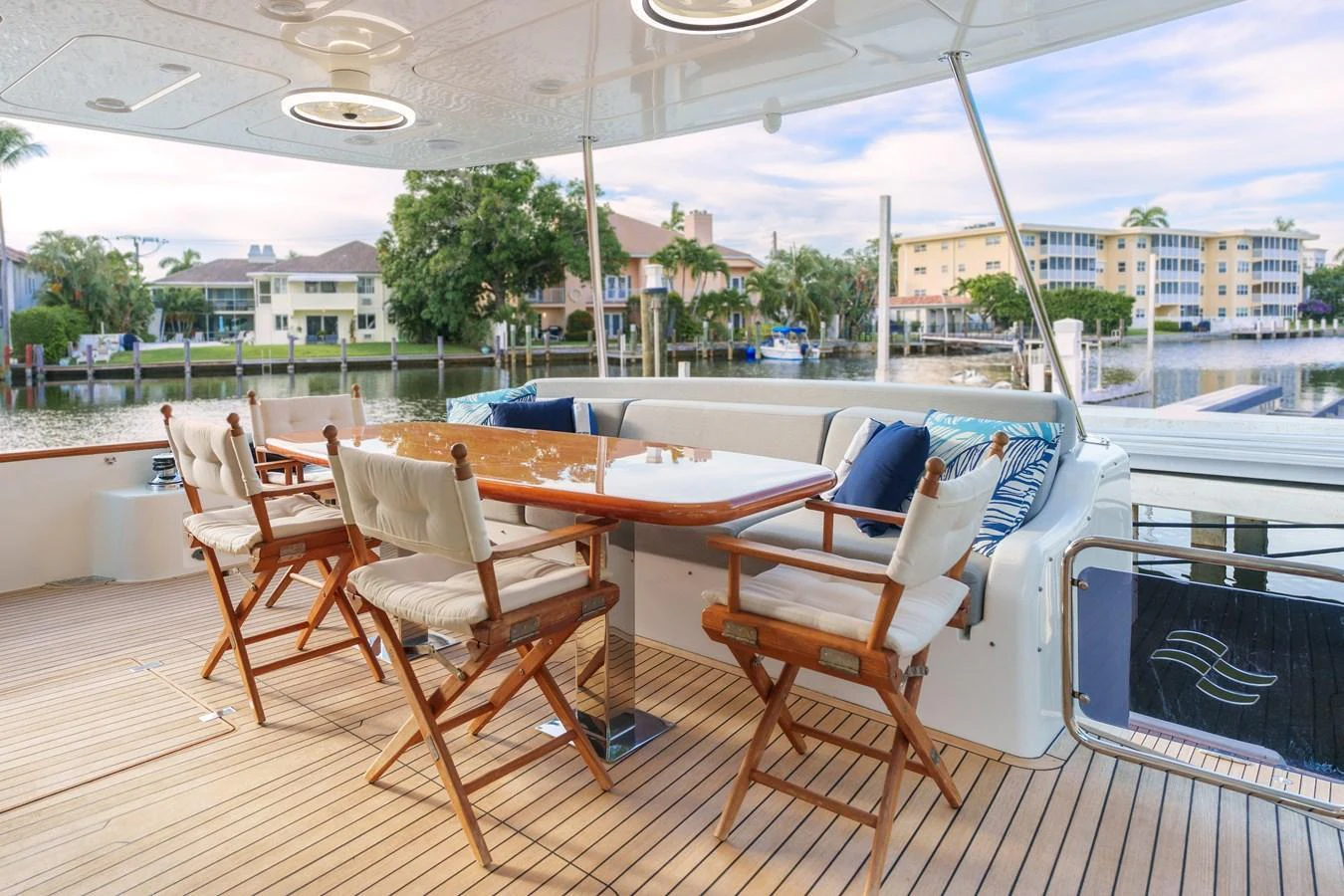 The aft deck features a comfortable dining area with a wooden table and cushioned chairs, perfect for al fresco meals. aboard FANTASEA Yacht for Sale